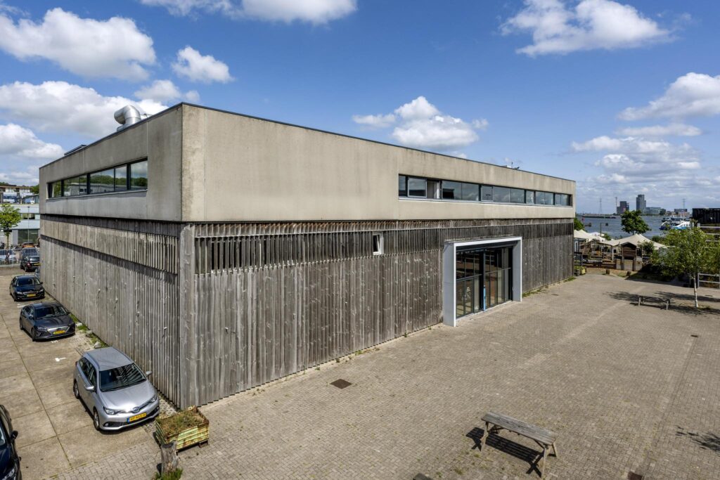 Modern industrial building on Johan van Hasseltweg with wooden facade and waterfront view in Amsterdam.